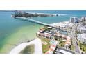 Aerial view of waterfront condominiums with pool, tennis court, beach, and bridge access at 825 S Gulfview Blvd # 202, Clearwater Beach, FL 33767
