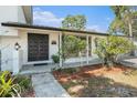 Inviting front entrance with well-manicured landscaping and a covered porch at 8302 W Pocahontas Ave, Tampa, FL 33615