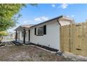 Attractive home with a covered porch, black shutters, and a newly installed wooden fence at 9135 Suffolk Ln, Port Richey, FL 34668