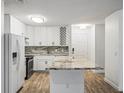 Bright kitchen featuring white cabinetry, an island with a marble countertop, and stainless steel appliances at 9481 Highland Oak Dr Dr # 508, Tampa, FL 33647