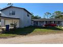 Charming two-story home with a front yard and a red car parked in front of the house at 9950 Morris Bridge, Tampa, FL 33637