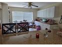 Bright kitchen featuring white cabinetry, a ceiling fan, and an adjacent dining area with a window at 9950 Morris Bridge, Tampa, FL 33637