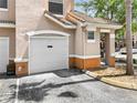 Side exterior showing the garage with white door and trimmed landscaping at 10434 Villa View Cir, Tampa, FL 33647