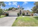 Well-maintained single Gathering home boasts a two-car garage and lush green lawn at 10509 Deepbrook Dr, Riverview, FL 33569