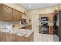 Kitchen featuring granite countertops, tile flooring, and black appliances at 10509 Deepbrook Dr, Riverview, FL 33569