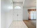 Bright foyer with double doors and tiled flooring seamlessly transitioning into carpeted living space at 11216 Longbrooke Dr, Riverview, FL 33579