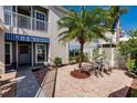 Charming courtyard with brick pavers, tropical foliage, and patio table and chairs at 11531 Shipwatch Dr # 1030, Largo, FL 33774