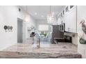 Bright kitchen featuring granite countertops, stainless steel appliances and modern pendant lighting at 11531 Shipwatch Dr # 1030, Largo, FL 33774