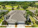 This aerial view showcases the home's roof, landscaping, and proximity to a serene pond at 1216 Lyndhurst Greens Dr, Sun City Center, FL 33573
