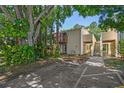 Charming condo exterior with lush greenery, a private balcony, and convenient parking spaces at 134 Sycamore Ln # H, Oldsmar, FL 34677