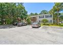 Condo exterior with assigned parking and inviting balconies, surrounded by beautiful mature trees at 134 Sycamore Ln # H, Oldsmar, FL 34677