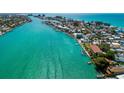 Stunning aerial view of a waterfront community with turquoise water and lush landscaping at 135 92Nd Ave # 2, Treasure Island, FL 33706