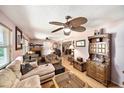 Spacious living room with hardwood floors, ceiling fan, and plentiful vintage furniture at 1399 Leeward Ave, Spring Hill, FL 34606