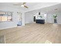 Open-concept living area with new ceiling fan, luxury vinyl plank flooring and freshly painted white walls and trim at 1711 S Patlin Cir, Largo, FL 33770