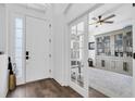 Bright entryway with a white front door, wood floors, and a view into a study with a built-in bookcase at 18714 Chemille Dr, Lutz, FL 33558