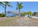 Charming single-story home featuring mature palm trees and a well-manicured lawn at 2004 Berry Roberts Dr, Sun City Center, FL 33573