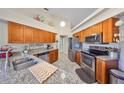 Bright kitchen featuring stainless steel appliances, granite countertops, and ample wood cabinetry at 2004 Berry Roberts Dr, Sun City Center, FL 33573