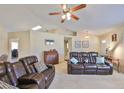 Comfortable living room with cozy leather seating, a ceiling fan, and neutral decor at 2004 Berry Roberts Dr, Sun City Center, FL 33573