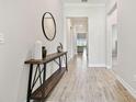 Inviting hallway featuring wood-look tile flooring, crown molding, and a stylish console table with decor at 21506 Snowy Orchid Ter, Land O Lakes, FL 34637