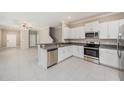 Modern kitchen features white cabinetry, granite countertops, and stainless steel appliances at 23378 Papyrus Way, Lutz, FL 33549