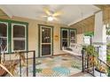 Inviting covered front porch boasts a swing, ceiling fan, and colorful pineapple patterned outdoor rug at 2450 3Rd N Ave, St Petersburg, FL 33713