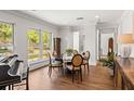 Bright dining area with hardwood floors, large windows, round table, and decorative piano at 2512 S Dundee St, Tampa, FL 33629