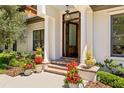 Elegant front porch with brick steps, white columns, and beautiful flower pots at 2512 S Dundee St, Tampa, FL 33629