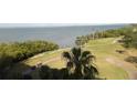 View of the golf course with palm trees, sand traps and pond, with Tampa Bay visible at 2616 Cove Cay Dr # 803, Clearwater, FL 33760