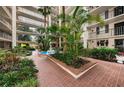 Beautiful courtyard with tropical plants, fountain and brick-paved walkway at 2699 Seville Blvd # 805, Clearwater, FL 33764