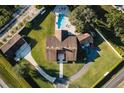 Aerial shot of a home with a pool, surrounded by a well-manicured lawn and mature trees at 2780 E Sam Allen Rd, Plant City, FL 33565