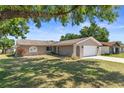 Single-story home with an attached two-car garage and a well-manicured lawn at 31076 Castle Ridge Drive, Brooksville, FL 34602