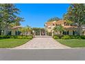 Grand estate featuring manicured lawns, palm trees and a gated entry with a brick driveway leading to the residence at 321 Brightwaters Ne Blvd, St Petersburg, FL 33704