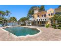 Inviting backyard showcasing a swimming pool, brick patio, covered lounge area, and waterfront views at 321 Brightwaters Ne Blvd, St Petersburg, FL 33704