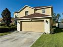 Exterior of a house featuring a two-car garage, lush green grass, and exterior lighting at 32111 Brookstone Dr, Wesley Chapel, FL 33545