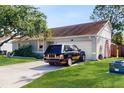 View of the home's exterior showing the garage, well-maintained lawn, and a dark colored SUV at 3238 6Th W Ave, Palmetto, FL 34221