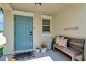 Charming front porch with a teal door and a welcoming bench with pillows at 3582 Hanover Dr, New Port Richey, FL 34653