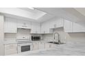 Modern kitchen features white cabinets, marble countertops, and stainless steel appliances at 3706 Greenery Ct # 206, Tampa, FL 33618