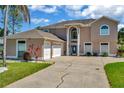Stunning two-story home with an attached three-car garage, blue door, and manicured front yard at 4612 Netherwood Dr, Tampa, FL 33624