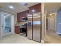 Open kitchen featuring stainless steel appliances, rich wood cabinets, granite countertops, and a glass accent door at 5449 Manatee Point Dr, New Port Richey, FL 34652