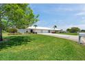 Charming home featuring a well-manicured lawn, vibrant landscaping, and a white tile roof at 6524 11Th W Ave # 5611, Bradenton, FL 34209