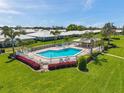 Beautiful community pool area featuring a fenced pool, lounge chairs, and palm trees at 6524 11Th W Ave # 5611, Bradenton, FL 34209