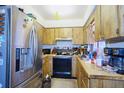 Functional kitchen featuring stainless steel refrigerator, ample cabinetry, and essential appliances at 6812 E 21St Ave, Tampa, FL 33619