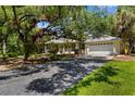 Exterior showcasing the home's driveway, lush landscaping, and well-maintained lawn at 710 N River Rd, Venice, FL 34293