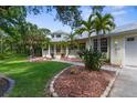 Charming front yard featuring lush landscaping, green grass, and a welcoming facade at 710 N River Rd, Venice, FL 34293