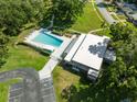 Aerial view of a community pool with lounge chairs and surrounding green space and parking at 834 Anchorage Ln, Palm Harbor, FL 34685