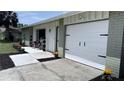 Exterior of a well-maintained home featuring a modern garage door, beautiful landscaping, and inviting curb appeal at 834 Anchorage Ln, Palm Harbor, FL 34685