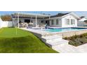 Outdoor pool featuring a putting green, outdoor bar, and comfortable seating at 8706 Driftwood Dr, Tampa, FL 33615