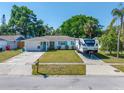 Well-maintained home with a neat lawn and an RV parked in the driveway at 9086 Enchantment Dr, Largo, FL 33773