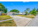 Single-story home with a well-manicured lawn and an RV parked in the driveway at 9086 Enchantment Dr, Largo, FL 33773