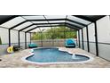 Enclosed in-ground kidney-shaped pool with water features and brick paver deck with lounge seating at 10005 Sage Creek Dr, Ruskin, FL 33573